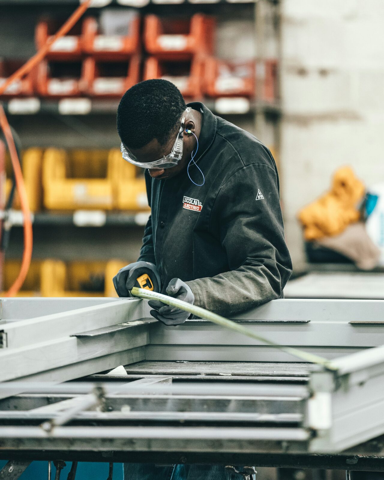 Fabrication worker grinding steel in a workshop