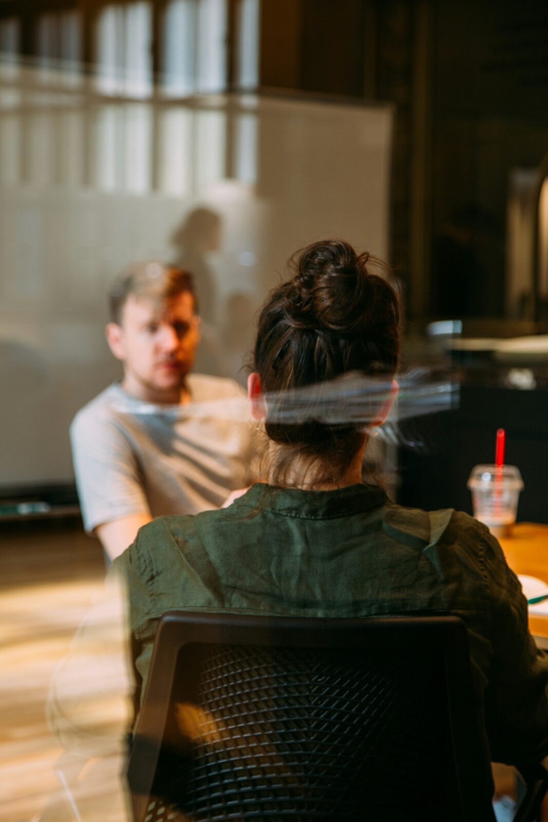 Two colleagues in discussion at a workplace meeting