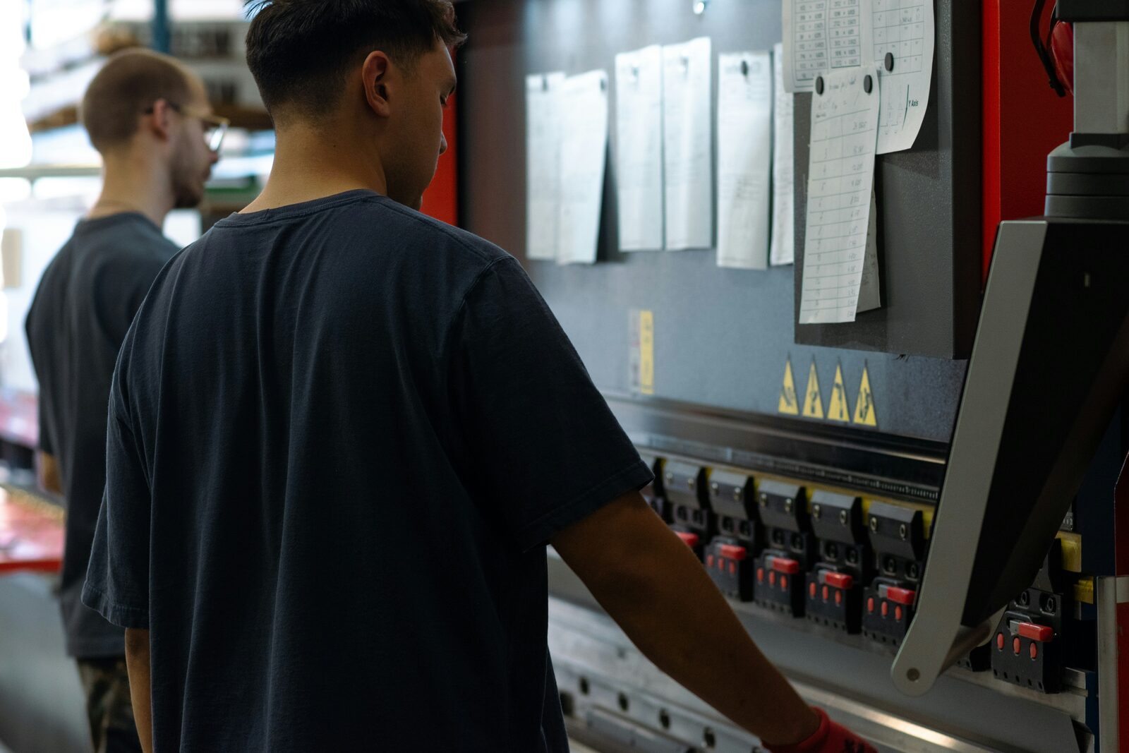 Operators working at a press brake on a production floor